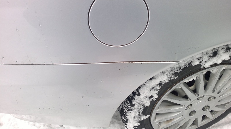 Naftatankin luukun ja muovipuskurin välistä pursuaa mujua